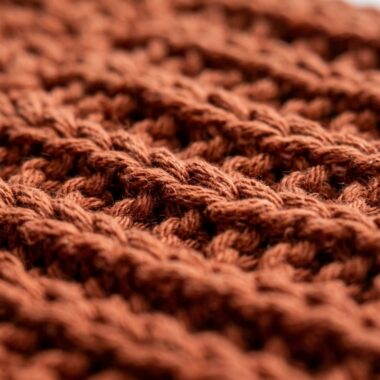 Ultra close-up macro texture of handmade double thick thermal crochet pot holder in natural terracotta cotton